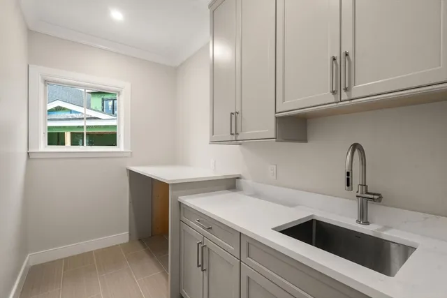 a kitchen with stainless steel appliances granite countertop a sink and a white cabinets with wooden floor