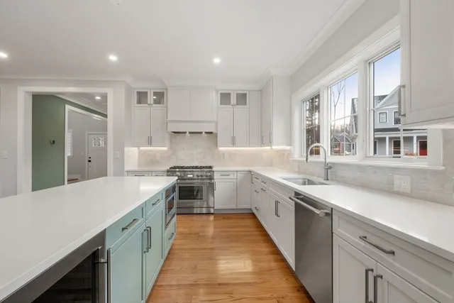 a large kitchen with stainless steel appliances lots of counter space and wooden floor