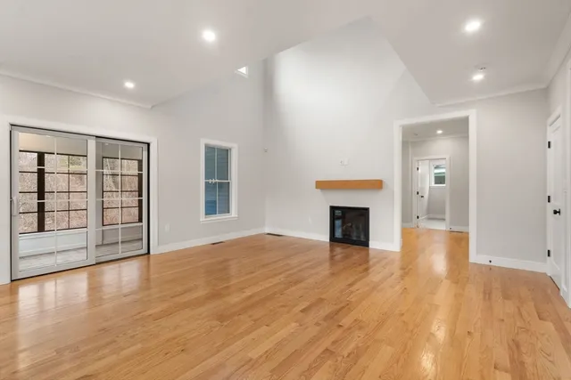 a view of a livingroom with wooden floor and a fireplace