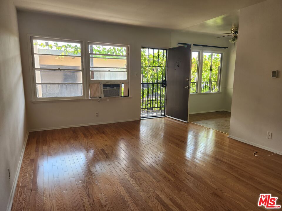 939 North Stanley Avenue, Unit 6 West Hollywood, CA 90046 - Photo 1 of 11 a view of an empty room with wooden floor and a window