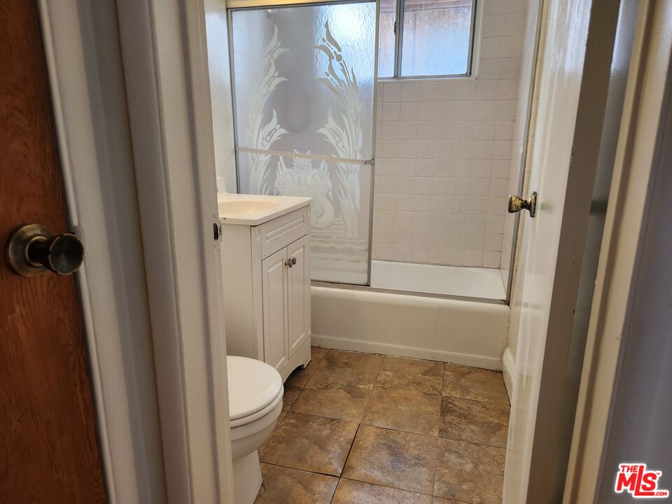 939 North Stanley Avenue, Unit 6 West Hollywood, CA 90046 - Photo 6 of 11 a bathroom with a granite countertop shower and a toilet