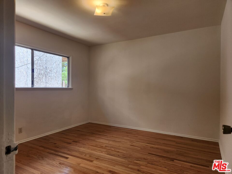 939 North Stanley Avenue, Unit 6 West Hollywood, CA 90046 - Photo 7 of 11 an empty room with wooden floor and windows