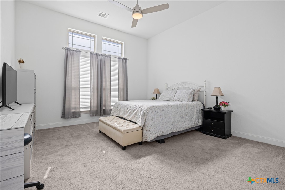 3009 Sage Ranch Drive Leander, TX 78641 - Photo 24 of 43 a spacious bedroom with a bed and a flat tv screen on the dresser