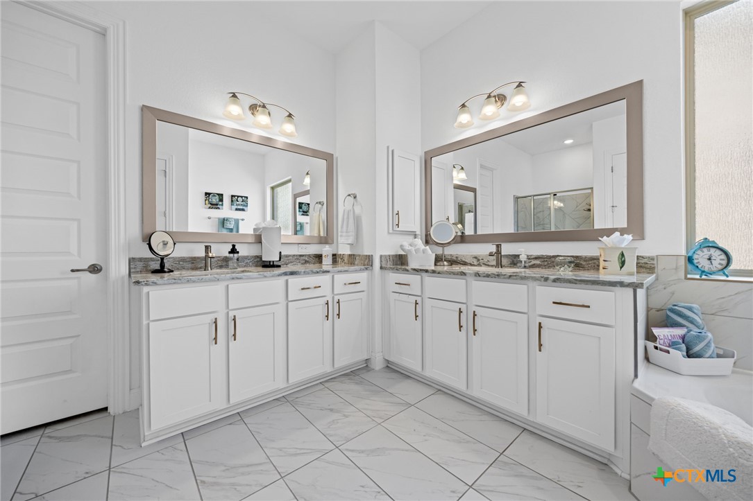3009 Sage Ranch Drive Leander, TX 78641 - Photo 29 of 43 a spacious bathroom with a granite countertop sink mirror and cabinets