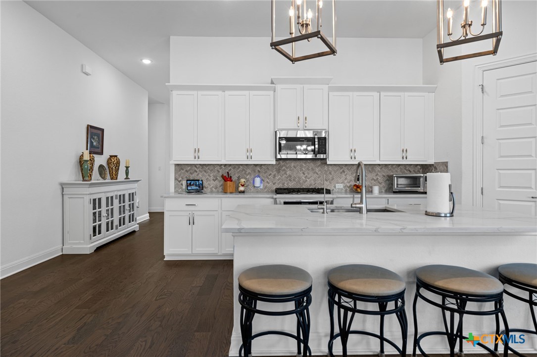 3009 Sage Ranch Drive Leander, TX 78641 - Photo 3 of 43 a kitchen with stainless steel appliances a dining table chairs refrigerator and cabinets