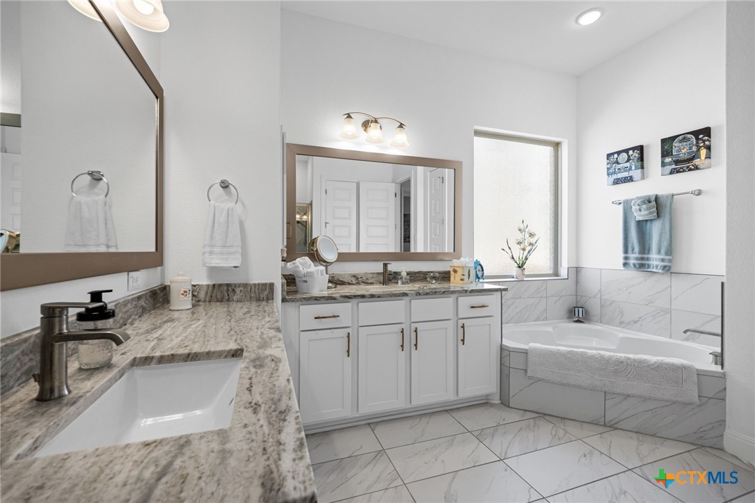 3009 Sage Ranch Drive Leander, TX 78641 - Photo 34 of 43 a bathroom with a granite countertop sink and a mirror