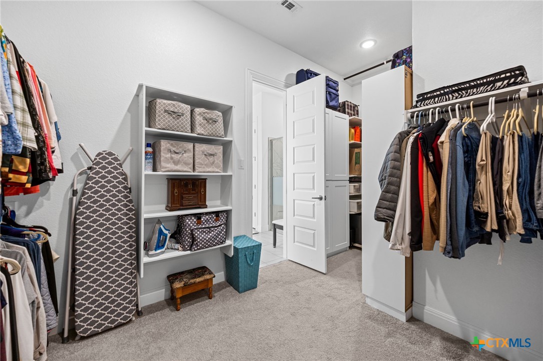 3009 Sage Ranch Drive Leander, TX 78641 - Photo 36 of 43 a view of walk in closet with clothes and shoes