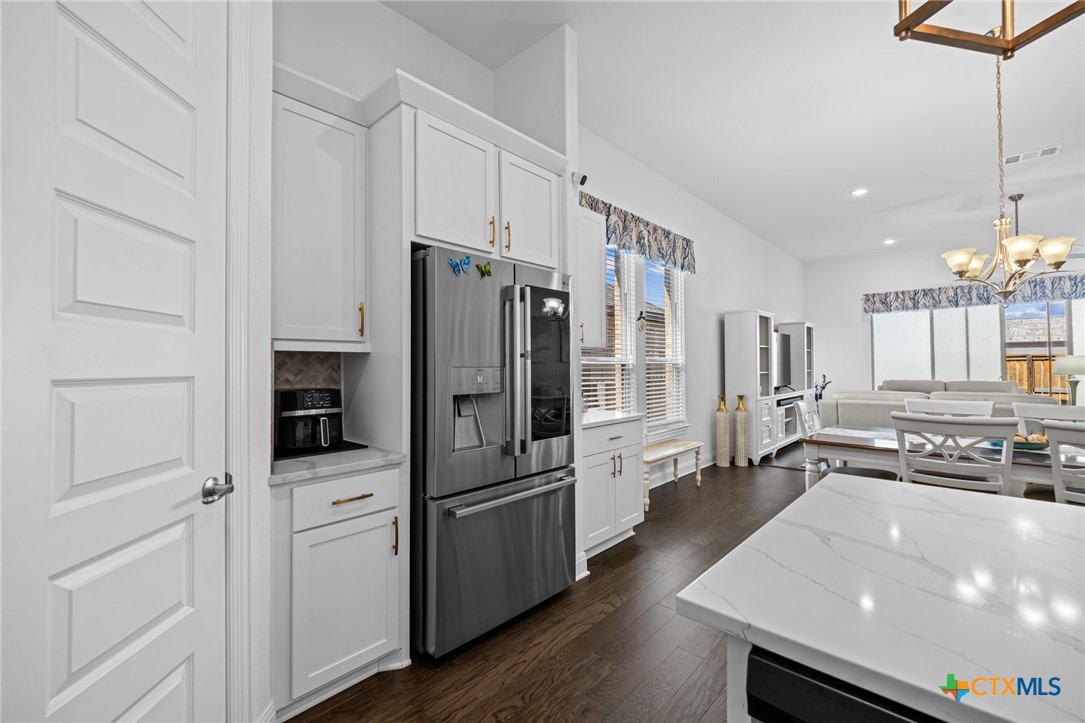 3009 Sage Ranch Drive Leander, TX 78641 - Photo 7 of 43 a kitchen with stainless steel appliances a refrigerator and a stove top oven