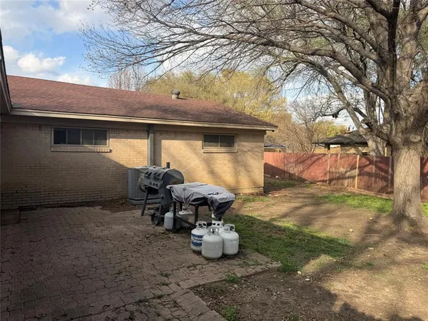 a view of a patio with table and chairs and a barbeque