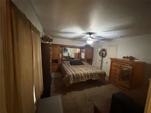 a spacious bedroom with a bed and a chandelier