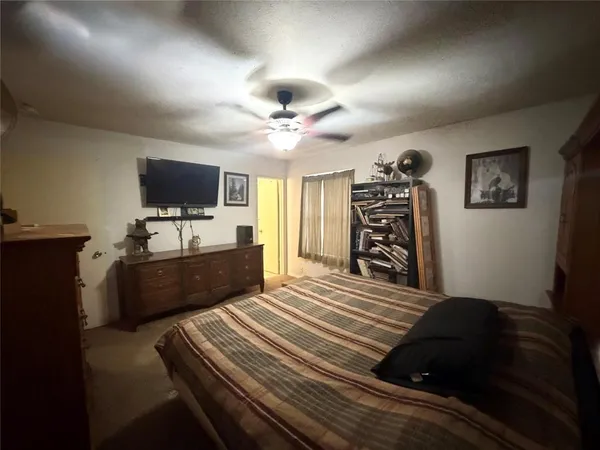 a bedroom with a bed and a flat tv screen on the dresser