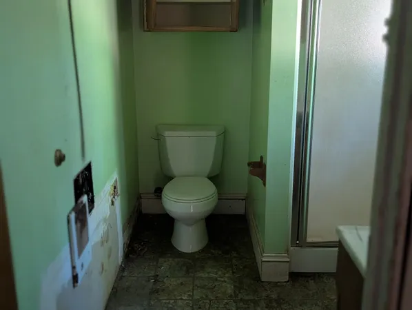 a white toilet sitting next to a small sink