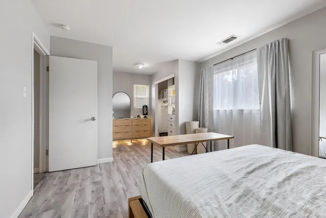 a bedroom with a bed and wooden floor