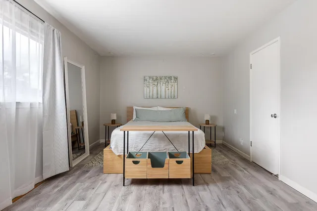 a bedroom with a bed and wooden floor