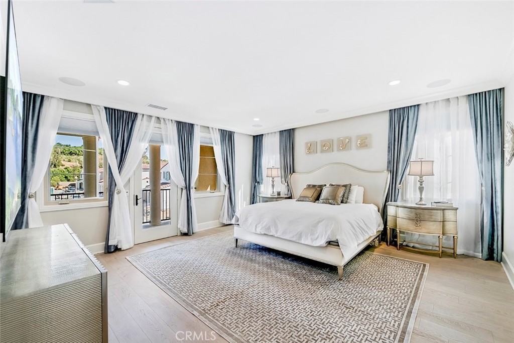 65 Rockinghorse Irvine, CA 92602 - Photo 23 of 43 a spacious bedroom with a large bed and a chandelier