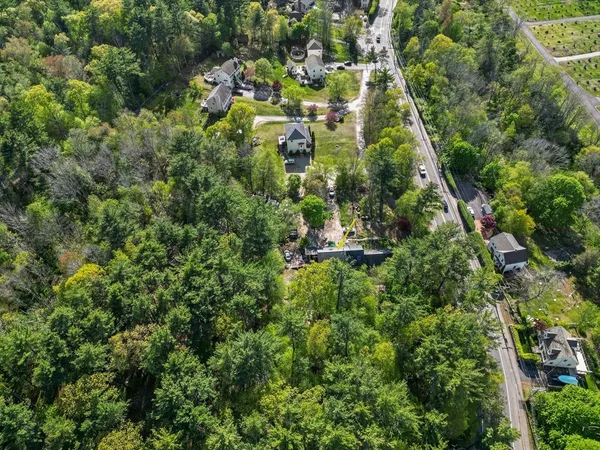an aerial view of residential houses with outdoor space and trees
