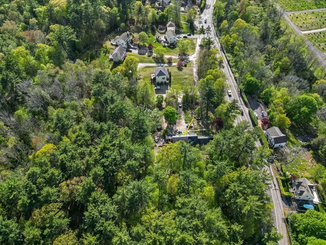 an aerial view of residential houses with outdoor space and trees