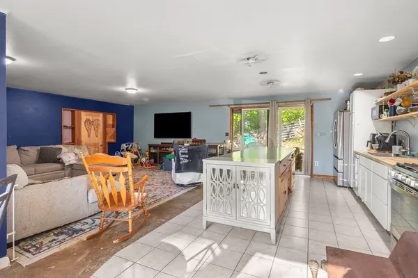 a living room with furniture a flat screen tv and a floor to ceiling window