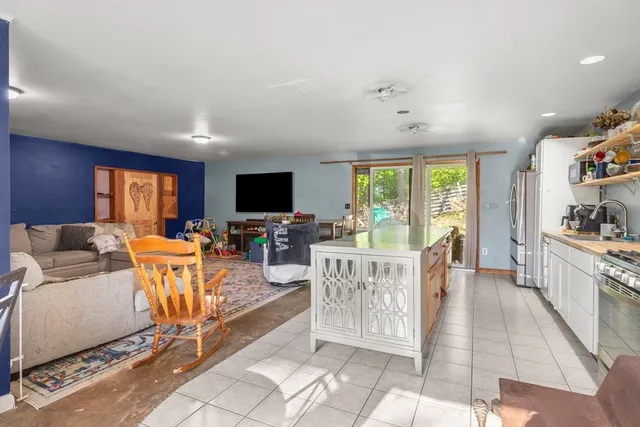 a living room with furniture a flat screen tv and a floor to ceiling window
