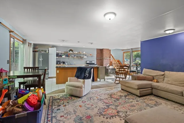 a living room with furniture and a dining table with kitchen view
