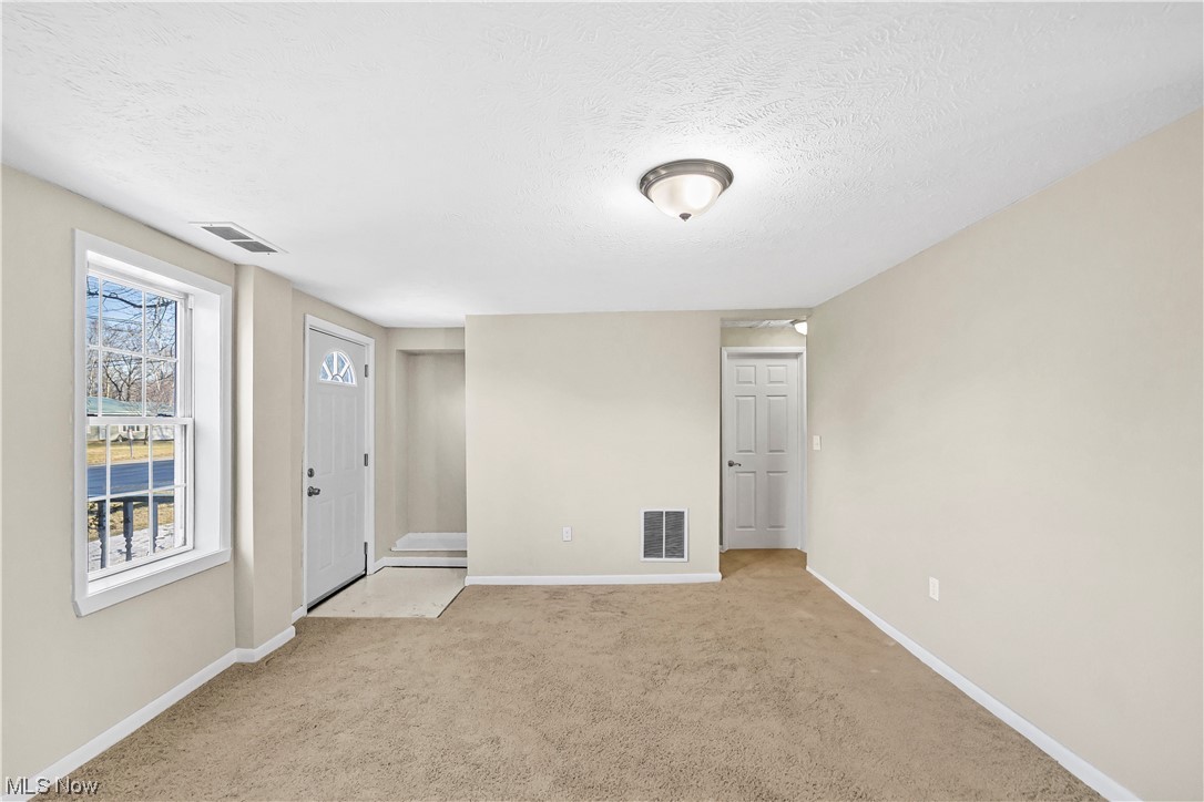 7038 Lake Road Madison, OH 44057 - Photo 11 of 17 Carpeted spare room featuring a textured ceiling