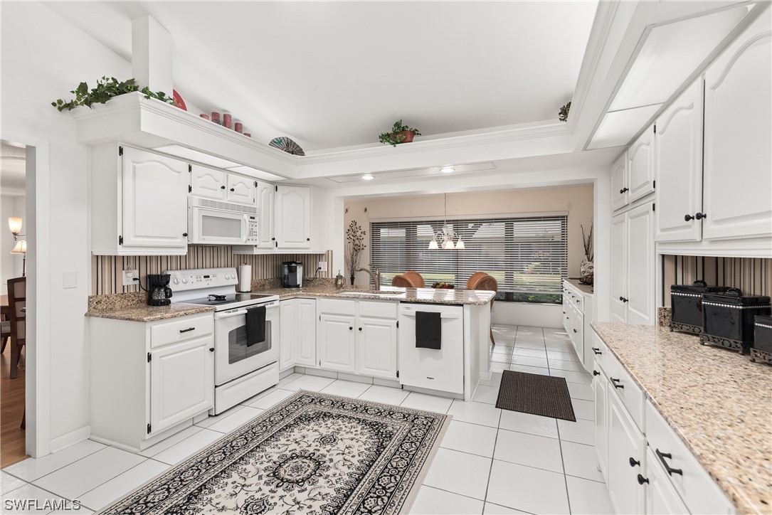 a large white kitchen with cabinets