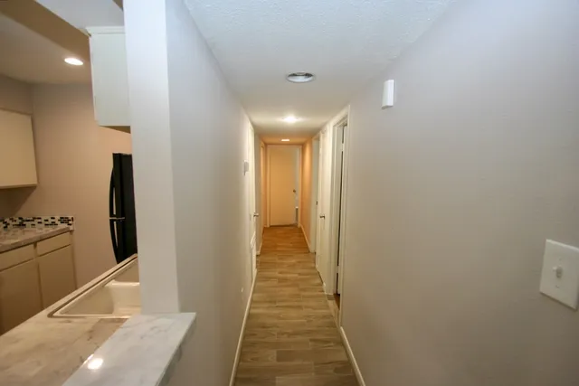 a view of a hallway with wooden floor and staircase