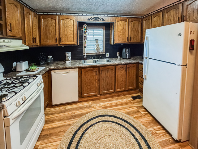 38569 North Sheridan Road, Unit 390 Beach Park, IL 60099 - Photo 9 of 28 a kitchen with a refrigerator sink and cabinets