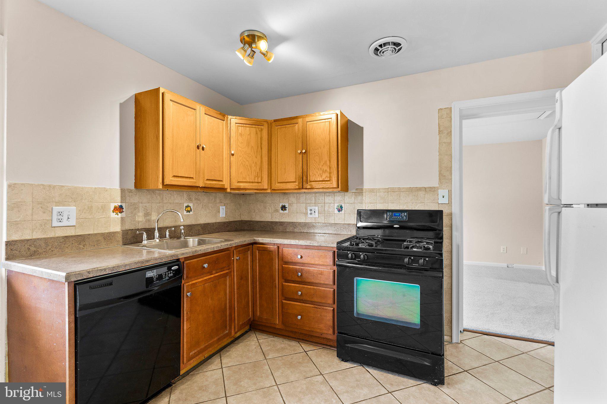 5930 Atteentee Road Springfield, VA 22150 - Photo 19 of 30 a kitchen with a stove sink and cabinets