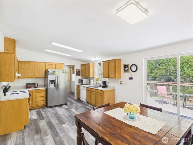 a kitchen with a table chairs refrigerator and stove