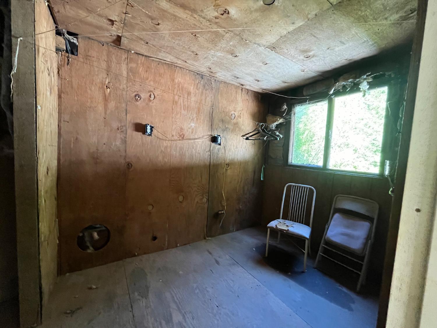 18035 Mobley Springs Road Nevada City, CA 95959 - Photo 5 of 29 a hallway with a chair and a wooden floor