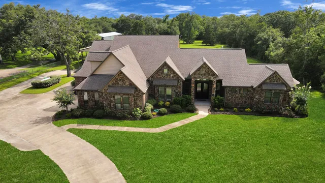 a aerial view of a house next to a big yard and large trees