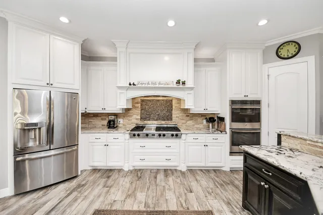 a large kitchen with stainless steel appliances granite countertop a stove a sink and a granite counter tops