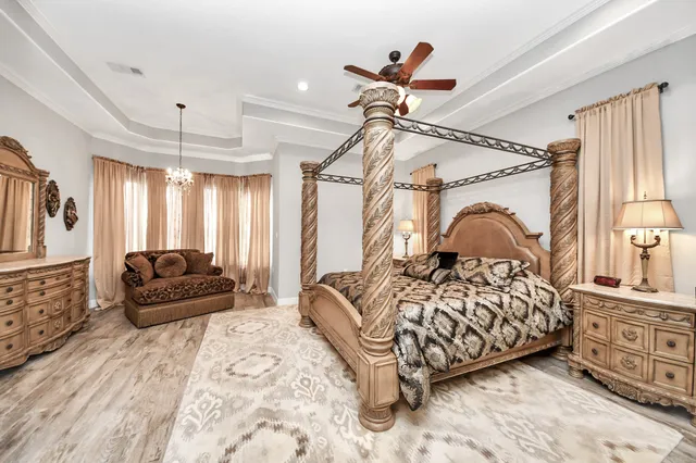 a spacious bedroom with a bed and a chandelier