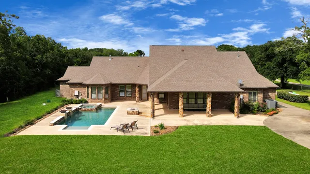 aerial view of a house with a yard patio and fire pit