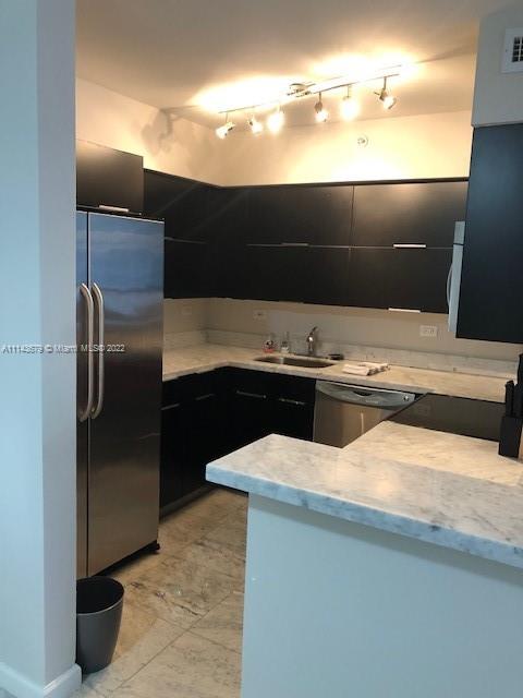 1500 Bay Road, Unit 958S Miami Beach, FL 33139 - Photo 2 of 20 a kitchen with stainless steel appliances kitchen island a refrigerator sink and stove
