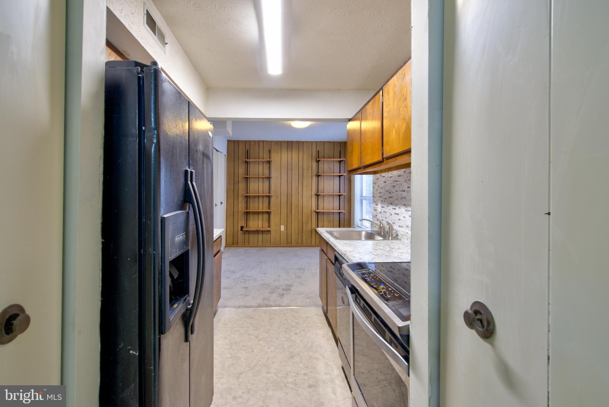 8011 Mandan Road, Unit 201 Greenbelt, MD 20770 - Photo 12 of 28 a kitchen with refrigerator and cabinets