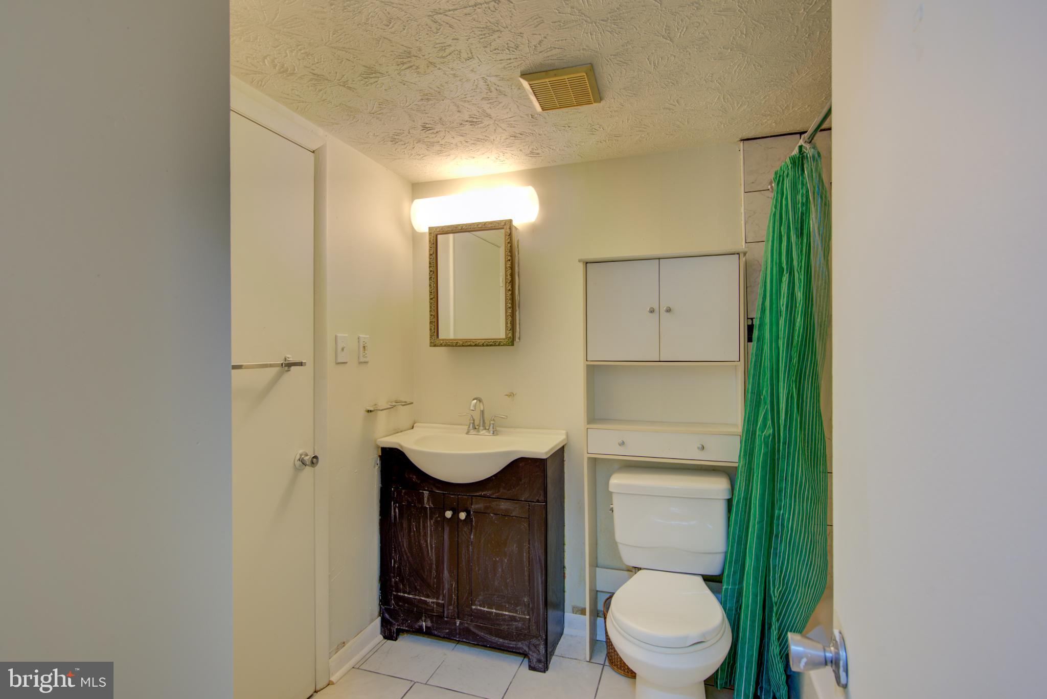 8011 Mandan Road, Unit 201 Greenbelt, MD 20770 - Photo 19 of 28 a bathroom with a toilet a sink and mirror