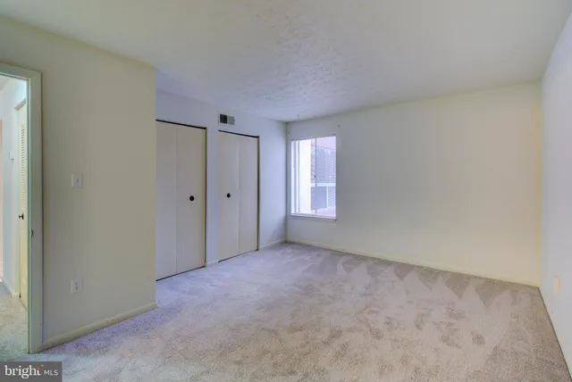 an empty room with windows and closet