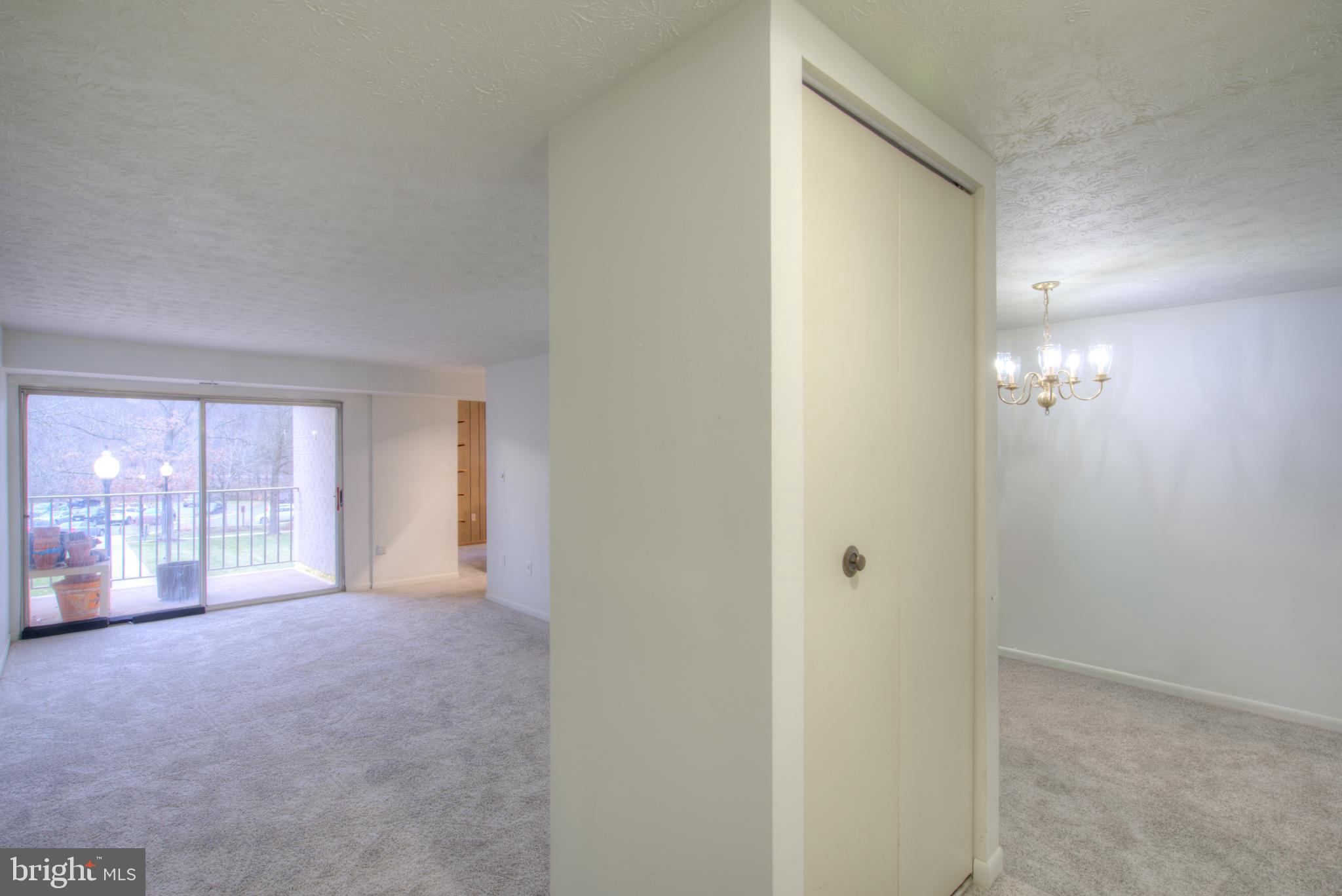 8011 Mandan Road, Unit 201 Greenbelt, MD 20770 - Photo 8 of 28 a view of a big room with windows and chandelier fan