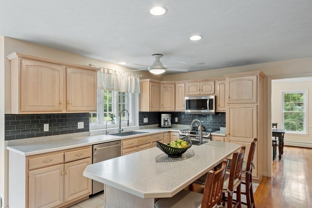 6 Farrar Road Upton, MA 01568 - Photo 10 of 42 a kitchen with a sink dishwasher a stove top oven a dining table and chairs with wooden floor