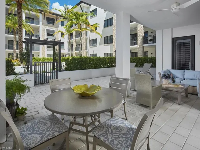 a view of a patio with table and chairs potted plants with wooden floor and fence
