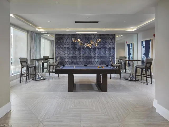 a living room with furniture a table and kitchen view