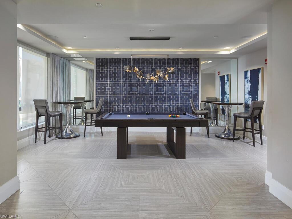 1135 3rd Avenue South Naples, FL 34102 - Photo 28 of 35 a living room with furniture a table and kitchen view