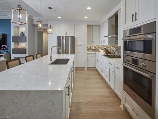 a kitchen with stainless steel appliances a stove sink microwave and cabinets
