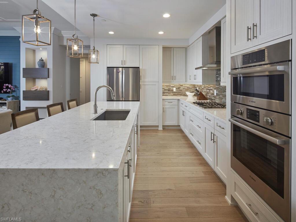 1135 3rd Avenue South Naples, FL 34102 - Photo 10 of 35 a kitchen with stainless steel appliances a stove sink microwave and cabinets