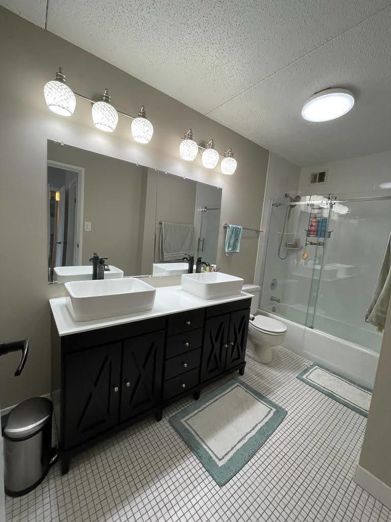 2015 South Finley Road, Unit 212 Lombard, IL 60148 - Photo 19 of 26 a bathroom with a double vanity sink a toilet and a shower