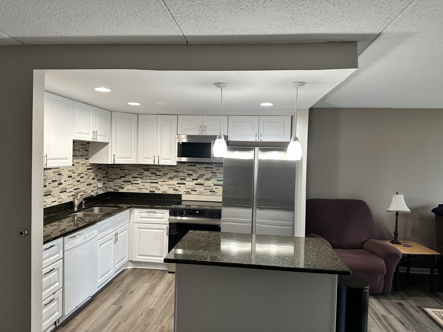 2015 South Finley Road, Unit 212 Lombard, IL 60148 - Photo 2 of 26 a kitchen with kitchen island granite countertop a sink cabinets and stainless steel appliances