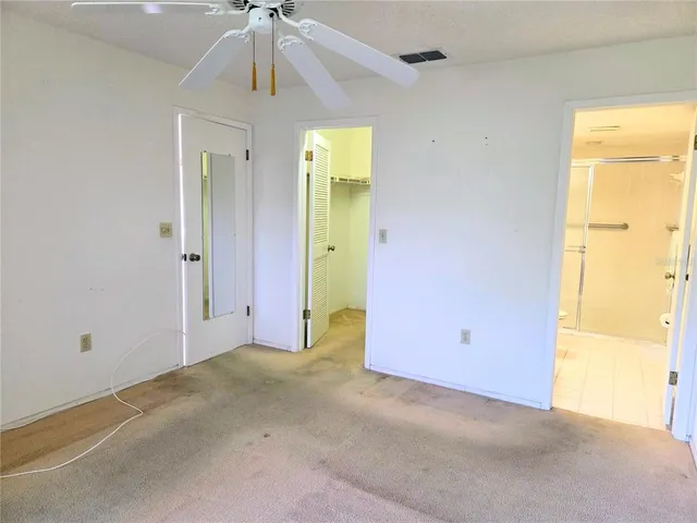 an empty room with a ceiling fan and a window