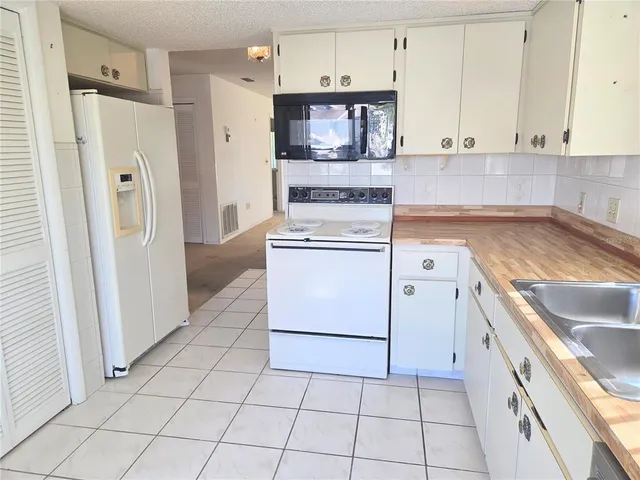 a kitchen with white cabinets and white appliances
